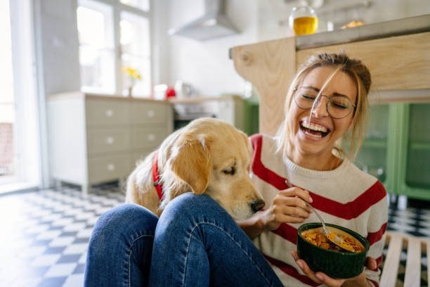 "Young woman with her dog in the kitchen in the morning | PetNatureHub"